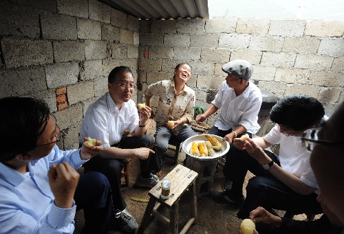 這是6月21日,溫家寶在甘肅隴南市康縣豆坪鄉(xiāng)豆坪村與受災(zāi)群眾一起吃土豆。 新華社記者黃敬文攝