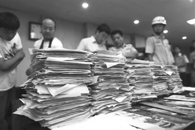 公民個人信息單、推銷商品話術(shù)單等涉案物品堆成“小山”。昨日,豐臺警方通報稱,“華夏國博”公司涉嫌利用非法獲取的公民個人信息,推銷廉價“藏品”,公司299人被拘留。本版攝影/新京報記者 浦峰