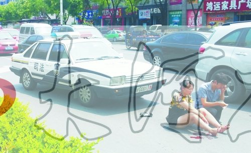 事故發(fā)生后,警車司機(右)下車查看傷者并撥打120,倆“領(lǐng)導(dǎo)”穩(wěn)坐車內(nèi)引發(fā)圍觀者不滿。